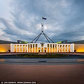 australia stock photography | Parliament House at Sunset, Capital Hill, Canberra, ACT, Australia. Parliament House, also referred to as Capital Hill or simply Parliament, is the meeting place of the Parliament of Australia, and the seat of the legislative branch of the Australian Government. Located in Canberra, the Parliament building is situated on the southern apex of the Parliamentary Triangle atop Capital Hill, at the meeting point of Commonwealth, Adelaide, Canberra and Kings Avenue enclosed by the State Circle. Parliament House was designed by Mitchell-Giurgola & Thorp Architects and it was opened on 9 May 1988 by Elizabeth II, Queen of Australia. The principal design of the structure is based on the shape of two boomerangs and is topped by an 81-metre (266 ft) flagpole. The flag above Parliament House is one of the biggest in Australia, measuring 12.8 metres by 6.4 metres.