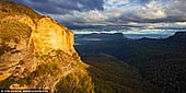 landscapes stock photography | Walls of Landslide Lookout, Mount Solitary and Jamison Valley at Sunset, Katoomba, Blue Mountains, NSW, Australia. Mount Solitary, a mountain that is part of the Blue Mountains Range, a spur off the Great Dividing Range, is situated within the Blue Mountains National Park, New South Wales, Australia. Mount Solitary is located approximately 100 kilometres (62 mi) west of Sydney, and a few kilometres south of Katoomba, the main town in the Blue Mountains. The local indigenous people called the mountain Korowal, meaning 'the strong one'. The origin of the contemporary name is obscure, but it may be based on the fact that Mount Solitary is the only mountain in the Jamison Valley. Mount Solitary is located in the middle of the Jamison Valley, one of the main valleys of the Blue Mountains region, immediately south of Katoomba. It is a long, low mountain of sandstone, stretching across the valley from west to east. Landslide Lookout is home to an interesting and debatable past as well as being home to 'never-ending' mountain and valley views as far as the naked eye can see. There are many boulders that cover a wide-range of the Lookout, cliff sides and lush vegetation. Landslide Lookout is one of those lookouts that make you feel insignificant standing next to the mighty and spectacular nature!