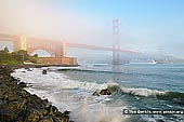 usa stock photography | The Golden Gate Bridge in Fog at Sunrise, San Francisco Bay, California, USA, Image ID US-SAN-FRANCISCO-GOLDEN-GATE-0003. Morning fog rolls through the San Francisco bay covering the Golden Gate Bridge as a cruise ship sails out of the bay and surf crashing at Fort Point, a National Historic Site, San Francisco, California, USA.