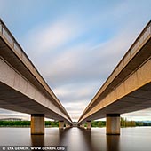 australia stock photography | Commonwealth Bridge at Sunrise, Canberra, ACT, Australia, Image ID AU-ACT-CANBERRA-0011. The Bridge is one of two major bridges crossing Lake Burley Griffin and is a critical component of the transport network of Canberra and the Australian Capital Territory overall. The Bridge also has considerable cultural and heritage value. The Bridge was built in the early 1960s. Since its opening, patronage on the Bridge has grown substantially. Current traffic on the Bridge makes it one of the busiest transport assets in Canberra.