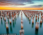 australia stock photography | Sunrise at Princes Pier, Port Phillip Bay, Melbourne, Victoria, Australia, Image ID AU-MELBOURNE-0027. Princes Pier is a 580 metre long historic pier on Port Phillip, in Port Melbourne, Victoria, Australia. It was known as the New Railway Pier until renamed Prince's Pier after the Prince of Wales (later Edward VIII) who visited Melbourne in May 1920. It was opened in 1915 and was able to accommodate the largest of steamers and mail ships. New Railway Pier was renamed Princes Pier in 1921 following the arrival in 1920 of the HMS Renown carrying H.R.H. Edward VIII, Prince of Wales. Over many decades, this pier has played a critical role in commerce, wartime embarkation and migration. With the advent of modern commercial air travel, arrivals to Princes Pier gradually declined from the 1970s. Closed in 1989, Princes Pier has been disused until its recent refurbishment. The redeveloped Princes Pier was launched as a public space in December 2011.