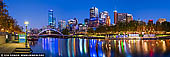 australia stock photography | Melbourne CBD, Rainbow Bridge and Flinders Street Station at Twilight, Southbank, Melbourne, Victoria, Australia, Image ID AU-MELBOURNE-0028. Explore the river by foot with an easy stroll around the banks of the River Yarra. Flinders Station with its heritage facade is your historic starting point. Walk over the Princess Bridge whilst admiring the rowers huffing and puffing in the waters below. The Melbourne Arts Centre and its towering spire greet you as you arrive at the southern side of the river. The Gallery of Victoria is adjacent with its ever changing exhibitions. Take the steps past the Arts Centre down to Southbank and its bustling cafes and bars. Wander along the Promenade along with other walkers, cyclists and joggers. It's the perfect vantage point to take in Melbourne's city skyline. Just a few hundred metres and your arrive at the Southbank pedestrian bridge with its distinctive curved architecture that will take you back to the city side. Stop mid-way for a drink or a coffee at the unique Ponyfish 'island' bar under the bridge and in the middle of the Yarra. It's a perfect spot to take in the evening dusk and admire the flotilla of boats, cruises and rowers maximising use of this great natural feature. Follow the bridge over the Yarra passing the collection of padlocks giving it a very Parisian feel. A short stroll east back towards and under Princess Street Bridge brings you to the arches alongside Federation Wharf with the Riverland Bar and its abundant range of beers, wine and refreshments to enjoy at any time of the day. It's a great place to end the day people and river watching.