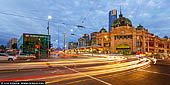 australia stock photography | Flinders Street Station at Night, Melbourne, Victoria, Australia, Image ID AU-MELBOURNE-0032. Opened on September 12th 1854, Flinders Street Station was the first railway station built in any Australian city. Melbourne Terminus, as it was called then was a collection of weatherboard sheds and on opening day, the first steam train journey in Australia left from the station to Sandridge (now Port Melbourne). By 1926, Finders Street Station became the busiest passenger station in the world, surpassing Gare Saint-Lazare in Paris, Grand Central Station in New York and Liverpool Street Station in London. On the January 11th 1922, The Argus Newspaper reported 200,000 passengers passed through the station in one day. A fixture of the station's facade, the clocks date back to the 1860s and continue to display departure times today. There was once a time when the clocks were manually operated by a railway officer who was tasked to change times on average of 900 times over an eight hour day. Now they are run automatically.
