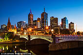 australia stock photography | Melbourne, Princes Bridge and Flinders Street Station at Dawn, Southbank, Melbourne, Victoria, Australia, Image ID AU-MELBOURNE-0041. Princes Bridge, originally Prince's Bridge, is an important bridge in central Melbourne, Australia that spans the Yarra River. It is built on the site of one of the oldest river crossings in Australia. Construction on the new bridge began in 1886 and was completed in 1888 in time for the second International Exhibition to be held in Melbourne. By that time the Yarra River had been heavily modified both upstream and downstream and the major floods of the early years were becoming less common. Constructed by David Munro to a design by Jenkins, D'Ebro and Grainger, it replaced an earlier timber bridge designed by Scottish born bridge designer David Lennox, whose earlier bridges in Sydney include the Lansdowne Bridge and Lennox bridge in Parramatta. John Grainger (1855-1917), the father of the Australian composer Percy Grainger, did the majority of the design work for the bridge, which was opened on 4 October 1888.