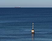 australia stock photography | The Pylon, Cottesloe Beach, Perth, WA, Australia, Image ID AU-PERTH-0005. The heritage listed iconic Cottesloe Pylon (also known as Cottesloe Buoy) has been in place since 1935. It is probably one of the most photographed subjects in Perth. The iconic pylon sits in the water off the beach and is the last remaining feature of the shark proof fence that once lay 80 meters off the beach. It is sometimes a venue for pranksters who want to make some political or sporting or whatever comment by altering its colours. It has provided generations of West Australians with a diving platform, one of three pylons built to anchor a shark net following a fatal attack in 1925. Two were destroyed by storms in 1937. Since then it has become an iconic landmark and popular diving platform for beach users. During major storm activity on 21-22 May 2009, the spike was knocked off the pylon. However this is not the first time this has occurred, during storms in 1995, the spike was also knocked over. Restoration works carried out were above water and more work on the subsea section of the pylon was planned for the future in order to repair the ageing concrete base.