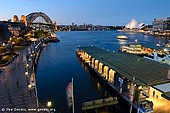 australia stock photography | Sydney Opera House and Harbour Bridge from Circular Quay, Sydney, New South Wales (NSW), Australia, Image ID AU-SYDNEY-CIRCULAR-QUAY-0005. From The Cahill Expressway visitors and tourists can see beautiful Sydney Opera House and The Harbour Bridge with The Circular Quay in the foreground. The best time to watch the scene is around sunrise or sunset when the bridge and buildings are illuminated with warm and cosy light from the low sun or from many lanterns and torches.