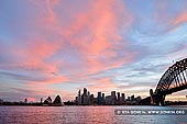 australia stock photography | Vivid Sunset Over The Sydney City CBD, Sydney, NSW, Australia, Image ID AU-SYDNEY-0014. Stock image of a vivid sunset highlighted the evening sky above the Sydney city skyline with the Sydney Opera House and the Harbour Bridge. This gorgeous scenery was captured from Kirribilli, Sydney, NSW, Australia.