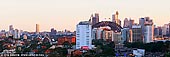 australia stock photography | Sydney City at Sunset, North Sydney, NSW, Australia, Image ID AU-SYDNEY-0020. Last rays of the setting Sun highlighted Sydney city with bright warm colours. The vivid colours of the sunset add to the beauty of the Sydney skyline. The city of Sydney's skyline with its high rise buildings include the tall thin Centrepoint Tower, the Opera House and the Harbour Bridge.