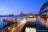 australia stock photography | Jeffrey Street Wharf at Twilight, Kirribilli, Sydney, NSW, Australia, Image ID AU-SYDNEY-0022. This stock photo shows the serene sunrise over the Sydney city from Jeffrey Street wharf in Kirribilli. Office lights glow from many of the office buildings in the misty morning of the busy city of Sydney.