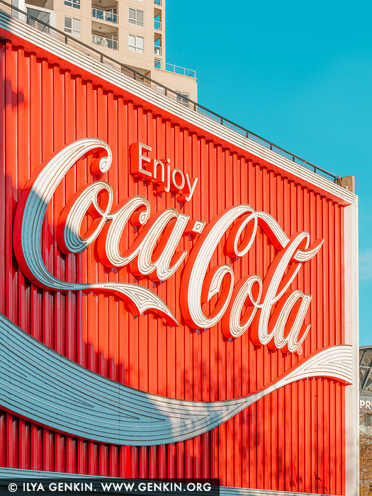 australia stock photography | Neon Nostalgia: Coca-Cola Sign at Kings Cross, Sydney, Kings Cross, Sydney, New South Wales (NSW), Australia. Radiant in bold red against a turquoise sky, the iconic Coca-Cola sign at Kings Cross captures both the energy and nostalgia of Sydney's most eclectic neighbourhood. A symbol of urban cool since the 1970s, this glowing landmark has become more than advertising - it's part of the city's cultural fabric. In this crisp, colour-rich photograph, the typography curves with retro flair, while the afternoon sun enhances every ridge and contour, turning commercial signage into pop art. This print brings a burst of vintage vibrancy and urban character - ideal for creative spaces, loft-style interiors, or collectors of contemporary culture.