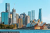 Harbour Harmony: Sydney Skyline and Opera House in Afternoon Glow - Fine art print of Sydney, New South Wales (NSW), Australia - Sydney's skyline rises in shimmering layers behind the sculptural curves of the Opera House, captured here from the water with a perfect balance of energy and calm. Bathed in soft afternoon light, the scene pulses with modern vibrancy - steel and glass towers reaching skyward while the iconic sails of the Opera House glow with golden warmth. The contrast of natural harbour blues and architectural geometry creates a rich visual rhythm, telling a story of a city that embraces both innovation and heritage. This fine art photograph offers a timeless view of Sydney's heartbeat - ideal for contemporary interiors, offices, or spaces that celebrate urban sophistication with a coastal soul. - Image ID: AU-SYDNEY-0036
