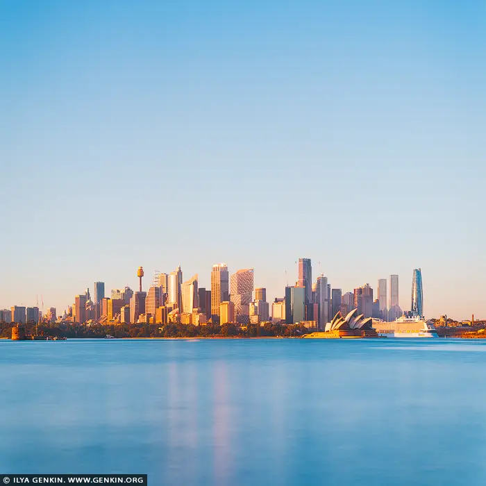 australia stock photography | Golden Morning Calm Over Sydney Harbour, Sydney, New South Wales (NSW), Australia. Soft morning light settles gently over Sydney just after sunrise, revealing the city in a moment of perfect balance and quiet elegance. From Cremorne Point, the skyline rises confidently above the harbour, bathed in warm golden tones that contrast beautifully with the cool, silky blue of the water below. The Sydney Opera House glows in the early sun, its iconic sails catching the light like sculpted porcelain, anchoring the composition with timeless grace. This is a portrait of Sydney at its most serene - when the city has awakened, yet the day has not fully begun. Glass towers reflect the first warmth of sunlight, while the harbour smooths into long, tranquil reflections, creating a sense of space and clarity. The expansive sky adds breathing room to the scene, amplifying the feeling of openness and calm that defines this fleeting hour. There is an understated optimism in this image, a sense of promise carried by the morning light. It invites the viewer to slow down, to appreciate the harmony between architecture, water, and sky, and to experience the city not through movement, but through stillness. The square format enhances this balance, making the composition feel grounded, refined, and effortlessly modern. Perfect for contemporary living rooms, offices, or minimalist interiors, this artwork brings warmth, light, and quiet confidence into any space. It serves as a daily reminder of calm beginnings, fresh perspective, and the enduring beauty of one of the world's most iconic harbour cities.