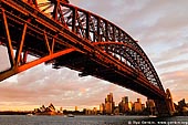 australia stock photography | Harbour Bridge at Sunset from Luna Park, Sydney, New South Wales, Australia, Image ID AU-SYDNEY-HARBOUR-BRIDGE-0004. Silhouette of the beautiful Sydney Harbour Bridge steel arches in Sydney, NSW, Australia. The Sydney Harbour Bridge may not be the longest steel-arch Bridge in the world, but it is the largest and widest. At 48.8 metres (151.3 feet) wide, the Guinness Book of Records lists it as the widest long span Bridge in the world and until 1967, it was Sydney's tallest structure. The Sydney Harbour Bridge was not originally thought of as an arch bridge. Dr. John Job Crew Bradfield initially had a cantilever bridge in mind to span the harbour. However, on a trip to New York he was inspired by the Hell Gate Bridge and he realised the cantilever design was inferior to an arch for his proposed bridge.