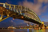 australia stock photography | Sydney Harbour Bridge at Night, Sydney, New South Wales (NSW), Australia, Image ID AU-SYDNEY-HARBOUR-BRIDGE-0009. This is a fantastic view of both the Sydney Opera House and the Harbour bridge on a late summers evening. The great variety of colour comes from the setting sun and the amazing light show that can be seen from the night lighting of the bridge, opera house and city behind.