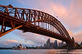 australia stock photography | Sydney Harbour Bridge at Sunset, Sydney, New South Wales (NSW), Australia, Image ID AU-SYDNEY-HARBOUR-BRIDGE-0013. The Sydney Harbour Bridge (Sydney's greatest tourism icon) - on a par with San Francisco's Golden Gate Bridge, New York's Statue of Liberty, London's Tower Bridge and the Eiffel Tower in Paris - took eight years to build and opened in March 1932. It also sometimes known as the 'coat hanger' or simply called 'The Bridge' by Sydneysiders. It has become an Australian icon. Not only is it a symbol of the incredible capabilities of construction, but also the strength and resilience of a nation which had been struck hard by the Depression and which found inspiration in the magnificent structure before them. The iconic Sydney Harbour Bridge spans the harbour at its narrowest point between Dawes and Milsons Points, where you see the bridge and the Sydney Opera House.