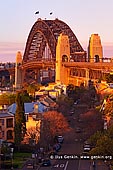 australia stock photography | Sydney Harbour Bridge in the Evening from Observatory Hill, Sydney, New South Wales (NSW), Australia, Image ID AU-SYDNEY-HARBOUR-BRIDGE-0023. Last light of the setting Sun highlighted the iconic Sydney Harbour Bridge while slightly smoky air from recent bushfires in national parks made nice red, orange and yellow glow at the bridge and houses nearby.