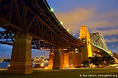 australia stock photography | Sydney Harbour Bridge at Night, Sydney, New South Wales (NSW), Australia, Image ID AU-SYDNEY-HARBOUR-BRIDGE-0012. Sydney Harbour Bridge is international icon for Sydney and Australia. It is  the widest and one of the longest steel arch bridges in the world. The bridge was planned in the early 20th century to span some 500m of harbour between the Sydney CBD and North Sydney, as part of a major upgrade of the Sydney city transportation network, which included the City Circle underground railway. The bridge was designed to take two rail lines from Wynyard Station in the CBD to Milson's Point in North Sydney - as well as six lanes of road traffic, two tram lines and a footpath on each side. After decades of argument and evaluations, onsite works started in July 1923, the main arch began in October 1928, and the structure opened for traffic in March 1932.