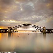 australia stock photography | Sydney Harbour Bridge at Sunrise Before Storm, A View from Blues Point Reserve, Sydney, New South Wales (NSW), Australia, Image ID AU-SYDNEY-HARBOUR-BRIDGE-0044. Changing weather conditions like approaching storm can create dramatic light. Bad weather is, by it's very nature, unpredictable. But great light can appear, either side of a weather front, and transform the landscape in most remarkable ways. You need to be there, properly attired, with your camera ready as these truly serendipitous moments are fleeting. Patience and a willingness to gamble on the result is also necessary. This photo of the the Sydney Harbour Bridge and the Opera House was created at sunrise right before the storm hit Sydney. The magnificent light lit the sky for only a couple of minutes and then gone leaving the sky dull and flat.