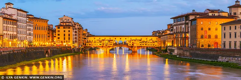 italy stock photography | Golden Reflections on the Arno - Ponte Vecchio at Dawn, Florence, Tuscany, Italy. As dawn gently awakens Florence, the Ponte Vecchio glows in a warm cascade of golden light, mirrored in the still waters of the Arno River. This iconic medieval bridge, lined with timeless shops and steeped in centuries of artistry, becomes a radiant focal point in the early morning calm. The soft pastel sky contrasts beautifully with the luminous façades of the riverside buildings, creating a moment of serene elegance that feels both historic and intimate. This fine art photograph captures not just a cityscape, but a feeling - one of quiet grandeur, old-world romance, and Florentine charm. Perfect for elevating a living room, study, or hallway with a sense of European sophistication and gentle tranquility.