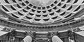  stock photography | The Pantheon Dome, Rome, Lazio, Italy, Image ID ITALY-ROME-PANTHEON-0002. The Pantheon in Rome is a marvel of ancient architecture, renowned for its massive dome and ingenious engineering. Built in 126 AD by Emperor Hadrian, its design combines classical elements with innovative construction techniques, showcasing the mastery of Roman engineering. The dome, with its oculus at the center, remains the world's largest unreinforced concrete dome, a testament to the ingenuity of Roman architects. Today, the Pantheon stands as a symbol of Rome's enduring architectural legacy, attracting visitors from around the globe to marvel at its timeless beauty and engineering prowess. In stark black and white, the Pantheon reveals its monumental grace-light and shadow tracing the curve of the ancient dome as it meets the sky. Below, weathered granite Corinthian columns rise with quiet strength, their fluted shafts and ornate capitals etched in timeless contrast. Stripped of color, the image emphasises texture, form, and the silent dialogue between architecture and eternity - a tribute to Roman engineering that still commands awe two millennia on.