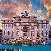 stock photography | Fontana di Trevi and Palazzo Poli at Sunrise, Rome, Lazio, Italy, Image ID ITALY-ROME-TREVI-FOUNTAIN-0001. Bathed in the fiery hues of a Roman dawn, the Trevi Fountain awakens in golden silence. The marble figures of Oceanus and his Tritons glow with warmth as the first rays of sunlight spill across the Piazza, igniting the cascading water with shades of amber and rose. Behind the fountain, the grand facade of the Palazzo Poli stands dignified and radiant, its Baroque details softened by the morning light. The usual crowds have yet to arrive, leaving the scene serene and timeless - a rare, dreamlike moment in the Eternal City where history, art, and light converge. The Trevi Fountain or Fontana di Trevi in Italian is an 18th-century fountain in the Trevi district in Rome, Italy, designed by Italian architect Nicola Salvi and completed by Giuseppe Pannini in 1762 and several others. Standing 26.3 metres (86 ft) high and 49.15 metres (161.3 ft) wide, it is the largest Baroque fountain in the city and one of the most famous fountains in the world. The origins of the fountain go back to the year 19 B.C., in which period the fountain formed the end of the Aqua Virgo aqueduct. The first fountain was built during the Renaissance, under the direction of Pope Nicholas V. Interestingly enough, the name of Trevi derives from Tre Vie (three ways), since the fountain was the meeting point of three streets. The building directly behind the Trevi Fountain in Rome is the Palazzo Poli. This historic palace, originally constructed in the 16th century and expanded in the 18th century, was specifically altered to serve as the monumental backdrop for the fountain. The Baroque south facade of Palazzo Poli was designed by architect Luigi Vanvitelli under the direction of Nicola Salvi, the creator of the Trevi Fountain, to integrate the fountain seamlessly into the palace's structure. Today, Palazzo Poli houses the Central Institute for Graphics (Istituto Centrale per la Grafica), and its grand Sala Dante offers exceptional views over the Trevi Fountain. The palace has a rich history, having been owned and renovated by several prominent families, and remains an important cultural and architectural landmark in Rome.
