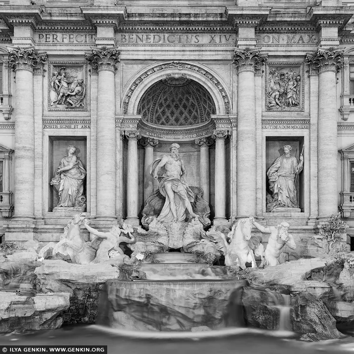 italy stock photography | Monochrome Majesty: Trevi Fountain in Detail, Rome, Lazio, Italy. In this evocative black and white study, the Trevi Fountain is stripped of color, revealing its purest form - a masterwork of line, texture, and timeless grandeur. Neptune stands poised in noble stillness, flanked by rearing sea horses and fluid figures that seem to defy the rigidity of stone. The absence of hue draws attention to every chiseled detail: the curves of marble, the tension in muscle, the cascade of water frozen in motion. This intimate fragment transforms the iconic into the abstract, inviting quiet contemplation. Ideal for minimalist or modern interiors, this piece brings classical elegance and sculptural drama to spaces that crave visual sophistication and historical depth.