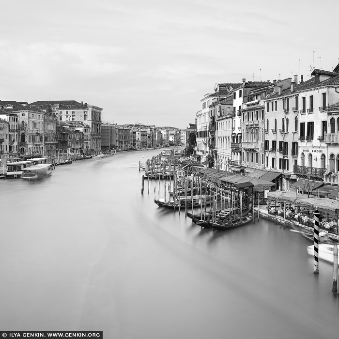 italy stock photography | Venice Grand Canal, Study 1, Venice, Veneto, Italy. Timeless Venice, stripped of color but rich in tone. This black and white long exposure, captured from the iconic Ponte di Rialto, transforms the Grand Canal into a dreamlike flow of light and shadow. The water dissolves into a soft, featureless haze, blurring the passage of time, while the historic facades - from Gothic arches to Renaissance lines - stand in crisp contrast. In daylight's calm, with nearly cloudless skies, the city's elegance emerges in pure form: all texture, rhythm, and geometry. A vision of Venice not as it is, but as it endures.