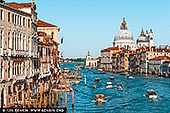  stock photography | The Grand Canal at Ponte dell'Accademia #1, Venice, Veneto, Italy, Image ID ITALY-VENICE-0007. Late afternoon sunlight bathes Venice in a golden glow as seen from the Ponte dell'Accademia. The Grand Canal, alive with gondolas and vaporettos, winds past historic palazzos toward the majestic Basilica di Santa Maria della Salute. This Baroque masterpiece, completed in 1687, was built as a votive offering after the 1630 plague decimated a third of Venice's population. Its luminous white dome, designed by Baldassare Longhena, rises above the cityscape, symbolising hope and resilience. From this vantage point, the interplay of light and water captures the timeless beauty of Venice.