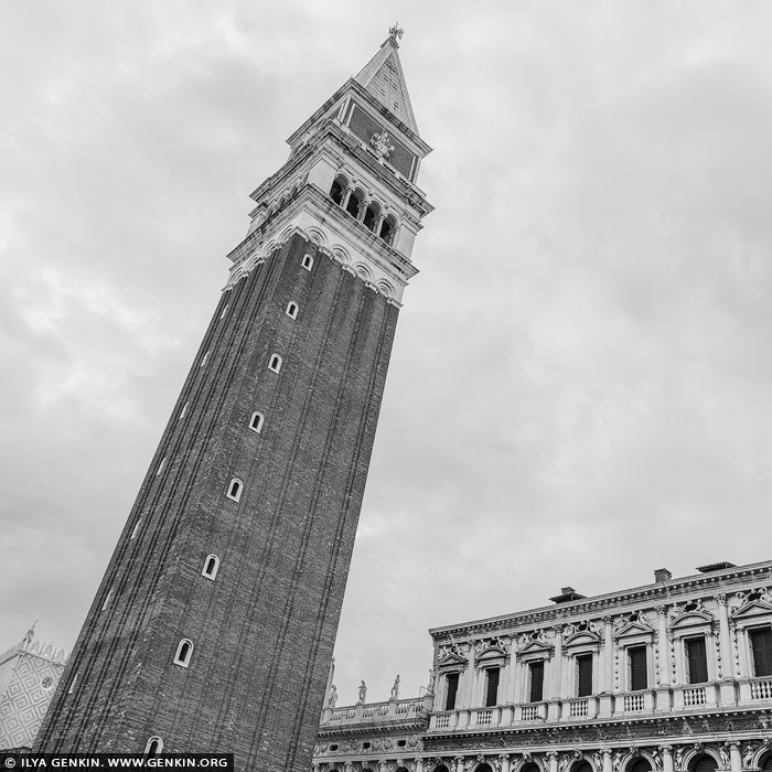 italy stock photography | St Mark's Campanile, Study 2, Venice, Veneto, Italy. In this black and white composition, St Mark's Campanile commands the Venetian skyline with stoic grace. Towering over Piazza San Marco, it has stood - in one form or another - for over a thousand years. The original tower, begun in the 9th century and completed in its iconic shape by the 16th century, tragically collapsed in 1902. What you see today is a meticulous 1912 reconstruction, faithful down to the brick. Stripped of color, the Campanile's geometry and textures take center stage - light and shadow sharpening its vertical drama, evoking the silence and endurance of centuries past.