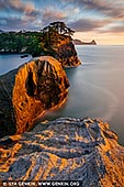  stock photography | Dogashima Islands at Sunset, Nishiizu Dogashima, Izu Peninsula, Shizuoka Prefecture, Japan, Image ID JAPAN-DOGASHIMA-0002. Dogashima in western Izu is famous for its dramatic stone formations, cliffs and caves formed by the lava flow of past volcanic eruptions and shoreline erosion. There are a great number of scenic spots on Dogashima Island, such as a national park, the Izu west coast, and Sanshiro Island, a natural treasure home to the rare 'tombolo phenomenon'. The best way to see the coast is from one of the frequently departing sightseeing boats, which briefly enter one of the larger caves. Visitors to Sanshiro Island during fine weather can also enjoy a sightseeing boat trip around the island. The cruises around Dogashima take about 20-25 minutes, although longer tours are also available.