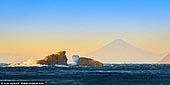  stock photography | Ushitsukiiwa and Mt. Fuji at Sunset, Kumomi, Izu Peninsula, Shizuoka Prefecture, Japan, Image ID JAPAN-KUMOMI-USHITSUKIIWA-0001. Two small islands can be seen off the coast of Kumomi. The view of Mt. Fuji seen beyond Ushitsuki Rock is beautiful and is loved by many photographers as a perfect camera point. The unusual name Ushitsuki Rock has the following reason. A long time ago, there was a storm in the year of the child, and the Kumomi area was flooded. All the houses and livestock were swept out to sea, but the next morning, the cows were washed ashore on the rocks in front of the port, and they were safe. Since then, the people of Kumomi have called this rock Ushitsuki-iwa. Even today, people call large rocks 'Oushigi' and small rocks 'Koushigi', build torii gates, put up shimenawa, and pray for the safety of harbors and ships.