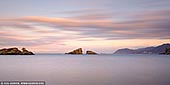  stock photography | Sunrise at Ushitsukiiwa, Kumomi, Izu Peninsula, Shizuoka Prefecture, Japan, Image ID JAPAN-KUMOMI-USHITSUKIIWA-0002. Two small islands can be seen off the coast of Kumomi. The view of Mt. Fuji seen beyond Ushitsuki Rock is beautiful and is loved by many photographers as a perfect camera point. The unusual name Ushitsuki Rock has the following reason. A long time ago, there was a storm in the year of the child, and the Kumomi area was flooded. All the houses and livestock were swept out to sea, but the next morning, the cows were washed ashore on the rocks in front of the port, and they were safe. Since then, the people of Kumomi have called this rock Ushitsuki-iwa. Even today, people call large rocks 'Oushigi' and small rocks 'Koushigi', build torii gates, put up shimenawa, and pray for the safety of harbors and ships.