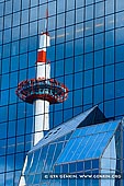  stock photography | Kyoto Tower Reflected in the North Facade of Kyoto Station, Kyoto, Kansai, Honshu, Japan, Image ID JP-KYOTO-0002. Standing 131 meters tall just across Kyoto Station, Kyoto Tower is Kyoto's tallest building and a rare modern iconic landmark in the city famous for its ancient temples and shrines. The tower was completed in 1964, the same year as the opening of the shinkansen and the Tokyo Olympics. A viewing platform is located 100 meters above ground and affords a 360 degree view of Kyoto and as far as Osaka on clear days. Kyoto Tower stands on top of a typical commercial building, which contains souvenir shops, restaurants and a hotel, as well as a public bath in the basement.