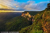 landscapes stock photography | Bridal Veil Falls at Sunrise, Govett's Leap Lookout, Blackheath, Blue Mountains National Park, NSW, Australia, Image ID AU-GOVETTS-LEAP-0004. The Govett's Leap Lookout has glorious panoramic views across the Grose Valley and to the right Govetts Leap Brook ends in the Bridal Veil Falls (Govetts Leap Falls) - the highest falls in the Blue Mountains at 180m. Govetts Leap was named after William Govett, one of the first surveyors of the upper Blue Mountains, in 1831. A horse and rider monument in the park beside the Great Western Highway at Blackheath village tells the story about Govetts Leap. There is a dramatic legend that tells of an escaped convict - turned bushranger named Govett who, pursued by troopers, found himself trapped on the edge of a 300 metre cliff. Preferring death to capture, he wheeled his horse around and together they leapt over the edge. To dispel the legend, Govetts Leap wasn't named because he jumped off the cliff at this point. The Scots Dialect Dictionary compiled by Alexander Warrack MA describes a 'leap' as a 'small cataract' - a cataract is a waterfall. Therefore Govetts Leap actually refers not to the lookout, but to the falls in Govetts Leap Brook, often known as Bridal Veil Falls.