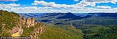 landscapes stock photography | The Three Sisters Panorama, Echo Point, Katoomba, Blue Mountains, NSW, Australia, Image ID THREE-SISTERS-BLUE-MOUNTAINS-0005. The Three Sisters are an unusual rock formation in the Blue Mountains of New South Wales, Australia, on the north escarpment of the Jamison Valley. They are close to the town of Katoomba and are one of the Blue Mountains' best known sites, towering above the Jamison Valley. Their names are Meehni (922 m), Wimlah (918 m), and Gunnedoo (906 m). The commonly told legend of the Three Sisters is that three sisters, Meehni, Wimlah and Gunnedoo, lived in the Jamison Valley as members of the Katoomba tribe. They fell in love with three men from the neighbouring Nepean tribe, but marriage was forbidden by tribal law. The brothers were not happy to accept this law and so decided to use force to capture the three sisters. A major tribal battle ensued, and the sisters were turned to stone by an elder to protect them, but he was killed in the fighting and no one else could turn them back. This legend is claimed to be an Indigenous Australian Dreamtime legend.
