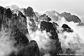 landscapes stock photography | Clouds Covered Huangshan Peaks, Cloud-dispelling Pavilion, Xihai (West Sea) Grand Canyon, Baiyun Scenic Area, Huangshan (Yellow Mountains), China, Image ID CHINA-HUANGSHAN-0030. Black and white photo of the cloud formations hover around the Huangshan mountain range and above the forest in Anhui Province of China.