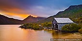 landscapes stock photography | Lake Dove Boat Shed at Sunrise, Cradle Mountain National Park, Tasmania, Australia, Image ID CRADLE-MOUNTAIN-LAKE-DOVE-TAS-0001. A beautiful view of Cradle Mountain, lake Dove, and the boat shed at sunrise in the Cradle Mountain National Park, Tasmania, Australia. The mountains covered in low clouds but the sun rays struggle through the fog and created dramatic scene. Dove Lake Boat Shed at Cradle Mountain was built in the early 1940's by the first park ranger, Lionel Connell. It sits on the edge of Dove Lake and is an ideal spot to sit, watch the sun set or rises and see the iconic Cradle Mountain.