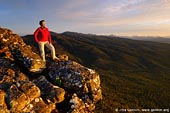 landscapes stock photography | Sunset at the Reed Lookout, The Grampians National Park (Gariwerd), Victoria, Australia, Image ID GRAMPIANS-0009. A female tourist in a casual sports outfit overlooking the Grampians National Park (Gariwerd) from the Reed Lookout at sunset in Victoria, Australia.