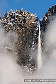 landscapes stock photography | Upper Yosemite Falls in Clouds, Yosemite National Park, California, USA, Image ID YOSEMITE-NATIONAL-PARK-CALIFORNIA-USA-0002. Upper Yosemite Falls waterfall after a spring snow storm visible through low early morning clouds. Yosemite Falls in Yosemite National Park, California, USA, at 2425 feet tall (730m) is the tallest waterfall in North America and fifth tallest in the world. It is a major attraction in the park, especially in late spring when the water flow is at its peak.