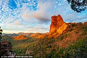 landscapes stock photography | Belougery Spire at Sunset, Warrumbungle National Park, New South Wales (NSW), Australia, Image ID AU-WARRUMBUNGLES-0005. The Warrumbungle National Park region was discovered by Europeans in 1818 by John Oxley while looking for an inland sea. The name of the mountain range, 'Warrumbungle,' means crooked mountains in the local Kamilaroi Aboriginal language. There is evidence of Aboriginal use and known occupation sites within the park. The idea of a reserve to conserve the area of the Warrumbungles was first entertained by the National Parks and Primitive Areas Council in 1936, with the first area being conserved in 1953. The national park takes up some 23 000 hectares, 33km west of Coonabarabran and 90km north of Gilgandra. More areas are to be added to the park in the future. It is a park of rocky spires, ridges, domes and gorges. The rocky peaks include the famous Breadknife, Bluff Mountain and Grand High Tops, which are an extremely popular destination for bush walkers.