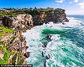 Tidal Ascent, Diamond Bay Cliffwalk in Sydney - Fine art print of Vaucluse, NSW, Australia - There is an invigorating calm in this sweeping coastal scene, where luminous water turns and gathers beneath towering stone. Living alongside it brings a sense of openness and release, as though the room itself has been given more air, more light, and more horizon. The late-morning glow sharpens the contrast between the vivid sea and the weathered cliff face, creating a mood that feels both energising and deeply centring. As a design anchor, this piece commands attention through its vertical sweep and layered interplay of turquoise, chalk white, and sunlit sandstone. These tones respond beautifully to natural light, giving the wall a fresh, radiant presence that shifts gently throughout the day. In refined residential interiors or executive spaces, it comes fully into its own in a commanding large-format museum presentation, where its scale expands the perceived boundaries of the room and allows the scene's full drama and elegance to breathe. - Image ID: AU-SYDNEY-DIAMOND-BAY-0001
