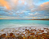 landscapes stock photography | Point Lowly Lighthouse, Eyre Peninsula, South Australia (SA), Australia, Image ID AU-POINT-LOWLY-LIGHTHOUSE-0001. Mathew Flinders explored the gulf in 1802. March 9, 1802 'at noon, the furthest hummock seen from the anchorage was distant four or five miles; it stands on a projection of low sandy land, and beyond it was another similar projection to which I gave the name of Point Lowly'. The lighthouse was built in 1883 after the conditions were found to be unsatisfactory for the continued use of a lightship at that location. Materials for it transported by sea from Port Pirie or the rough coastal road from Port Augusta. The city of Whyalla (30km away) did not exist at the time. The lighthouse and its cottages pre-date the establishment of Whyalla and are the oldest European heritage structures in the Whyalla area. The original lighthouse was a 15 metres high sandstone tower with the optical apparatus imported from Chance Bros. England. It was first lit on 1 February 1883. After several incidents north of Point Lowly, the tower was extended to its current height of 22.8 metres in 1909. The first light was an oil wick burner until replaced in 1900 by a kerosene mantle type and then an automatic electric light in 1973.