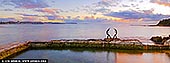 Quiet Communion, The Fairy Bower pool in Manly - Fine art print of Sydney, NSW, Australia - At first light, the Oceanides stand in silent conversation above the tidal pool, their curved forms echoed by the softened horizon. Blush pink, lavender and pale gold move gently across sea and sky, bringing a sense of stillness, emotional balance and expansive breathing room into daily life. As a commanding design anchor, this panoramic artwork introduces refined coastal colour to residential interiors, executive offices and sophisticated hospitality spaces. Its cool blue-violet tones settle beautifully into natural light, while the warmer sunrise accents lend quiet radiance; presented in a commanding, large-format museum presentation, the scene truly comes alive, widening the visual boundaries of the room. - Image ID: AU-MANLY-BEACH-0008