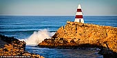 landscapes stock photography | Waves Crushing at Obelisk, Robe, Limestone Coast, South Australia, Australia, Image ID AU-ROBE-0002. Robe in South Australia is a small town fishing port with a population of about 1,500 people. The town was named after Major Frederick Robe, which founded the area as a shipping port in 1845. During the gold rush era of 1857 thousands of Chinese immigrants landed at Robe on destination to Ballarat and Bendigo. Robe attracts many tourists seeking a seaside holiday. Long Beach is a popular beach for swimming, surfing and fishing. Long Beach is also one of Australia's few beaches left where you can still drive your vehicle along the beach due to its firm sand composition. The rugged rocky cliffs around Robe also provide ideal fishing and diving conditions. The best spots to fish include Rock fishing in Guichen Bay, wharf fishing at Lake Butler Boat Haven Channel or surf fishing between Long Gully and West Beach. A great attraction to Robe is the Obelisk shipping marker found at Cape Dombey. It was built in 1855 and stands 12m (40 ft) high and is 30m (100 feet) above sea level. The noticeable red and white bands help guide mariners when boating.