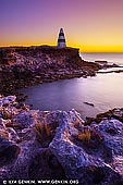 landscapes stock photography | Cape Dombey Obelisk at Sunset, Robe, Limestone Coast, South Australia, Australia, Image ID AU-ROBE-0003. Robe's southern headland was originally named Cape Lannes by the French explorer Nicolas Baudin but its name was changed by Captain Matthew Flinders to Cape Dombey around the early 1800's. Robe was founded by the South Australian Government in 1846 only 10 years after the Province of South Australia had been first settled, became an international port trading directly with London and later the site where 16,262 Chinese landed and walked to the Victorian Goldfields. Cape Dombey's most striking feature is the 40 foot tall red and white striped Obelisk which stands 100 feet above sea level, defying rough weather and decaying limestone cliffs at this dramatic point. Built in 1855 by local builder George Shivas at a cost of 230 pounds, the limestone was carted to its site by a 32 bullock wagon team. Originally mariners were unhappy with the white painted Obelisk, as it was still difficult to differentiate the marker from Long Beach's white sand hills and the limestone cliffs of the coast. In 1862 the Obelisk was repainted in alternate red and white horizontal bands and it can now be seen from a distance of 20 kilometres on a clear day. Given the South East coast's notoriety for shipwrecks, with 30 wrecks occurring in Guichen Bay in 1853 alone, the Obelisk was used to store rockets fired to distressed ships which carried life lines and baskets for bringing passengers ashore thus saving many lives. Numerous dances at the local hotels, including the Caledonian Inn, were interrupted as fired rockets were heard and revellers in their finery deserted the venue to go to the aid of floundering ships. Upstairs at the Caledonian Inn you can find scrolled teak doors salvaged from the 1857 wreck of the Koenig Willem. The Obelisk has been repainted several times, the last in 2002 by the Save the Obelisk Society.