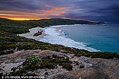 landscapes stock photography | Cable Beach at Sunrise, Torndirrup, Western Australia (WA), Australia, Image ID AU-WA-ALBANY-CABLE-BEACH-0001. Cable Beach, next to The Gap and Natural Bridge, is rough and treacherous. There is a giant boulder in the middle of the Cable Beach which was lifted by the force of the waves and placed onto the stones. It's a wonderful, dramatic beach to walk along but most days it's far too dangerous for swimming. It has a lot of rocks and reef close to shore and pummelled by huge waves. Cable Beach is accessible only by a descent which may also be referred to as a bit of a hike! The staircase descends from the carpark onto the rocky boulders which continue for at least twice as long as the stairs down onto the beach.