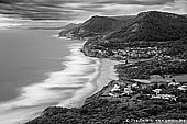 landscapes stock photography | Stanwell Park from Bald Hill Lookout, Illawarra, New South Wales (NSW), Australia, Image ID AU-STANWELL-PARK-0001. Black and white view from Bald Hill Lookout over Stanwell Park valley to Mount Mitchell, and the site of the Sea Cliff Bridge in the background. Stanwell Park is a picturesque coastal village and northern suburb of Wollongong, NSW, Australia. It is the northernmost point of the Illawarra coastal strip and lies south of Sydney's Royal National Park. It is situated in a small valley between Bald Hill to the north, Stanwell Tops to the west and Mount Mitchell to the south. It has two lagoons from the village's two creeks, Stanwell and Hargrave Creeks, and a beach running between headlands. Bald Hill is one of Illawarra, Australia's best known and most popular lookouts, situated atop the hill of that name. Not only are the views excellent, the area is also internationally known as a major hang gliding centre.