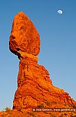 landscapes stock photography | Moon Rising Over The Balanced Rock, Arches National Park, Utah, USA, Image ID US-UTAH-ARCHES-NATIONAL-PARK-0002. Stock image of the Moon rising over the Balanced Rock in Arches National Park, Utah, USA at sunset. Balanced Rock is one of the park's iconic balanced rock sculptures, and has laid out a small trail for vantage points all around. The Balanced Rock in Arches National Park in Utah looks as if it was carefully placed on the stand, but in reality, the sandstone around it wore away. It will fall down eventually. A smaller balanced rock, called Chip Off the Old Block, fell off its pedestal decades ago.