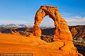 landscapes stock photography | Delicate Arch at Sunset, Arches National Park, Utah, USA, Image ID US-UTAH-ARCHES-NATIONAL-PARK-0008. Delicate Arch has become the unofficial symbol of Utah. Towering eighty feet (the arch is a 52ft or 16m tall) over hikers, Delicate Arch is one of the highlights of Arches National Park and is possibly the most beautiful arch in the world. This arch needs to be experienced in person to be really appreciated. It is depicted on Utah license plates and on a postage stamp commemorating Utah's centennial anniversary of statehood in 1996. The Olympic torch relay for the 2002 Winter Olympics passed through the arch.