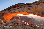 landscapes stock photography | Sunrise at Mesa Arch, Island in the Sky, Canyonlands National Park, Utah, USA, Image ID CANYONLANDS-NATIONAL-PARK-UTAH-USA-0003. Mesa Arch is a famous structure in the Island in the Sky District of Canyonlands National Park above Colorado River near Moab in Utah, USA. Impressive photos show rugged canyon country in the distance framed by a close-up view of the photogenic arch. Some of the best photos are taken at sunrise when the arch glows red and orange.